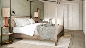 A four-poster bed with a wooden frame, a nightstand with a lamp, a bedside table with a lamp, a mirror, and a framed picture on the wall.