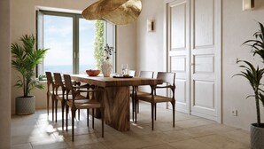 A dining area with a wooden table, chairs, and a hanging light fixture.