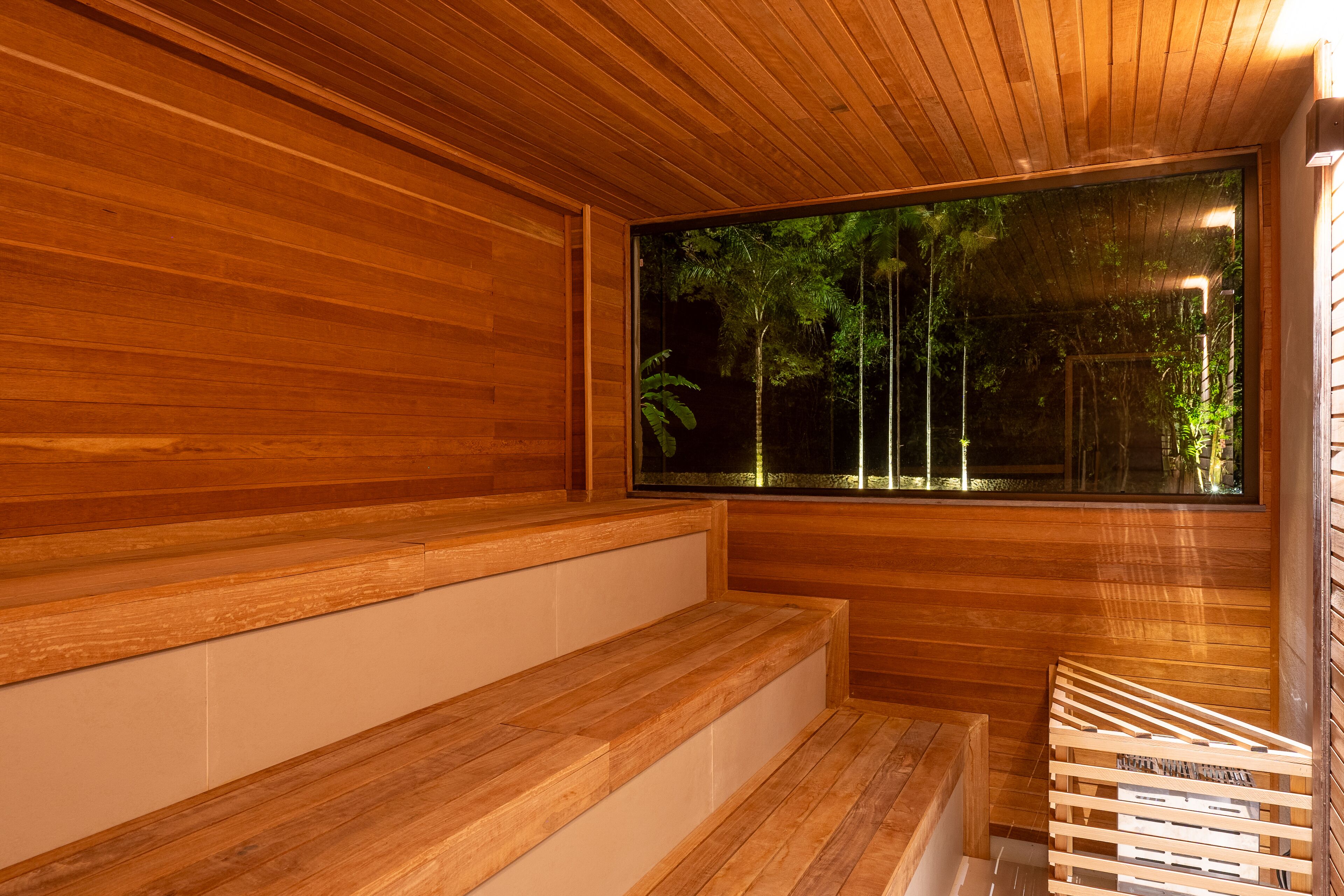 A wooden interior with a large window, wooden steps, and a bench.