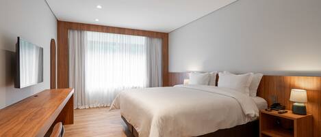 Una habitación de hotel moderna con una cama de madera, un escritorio y una televisión.