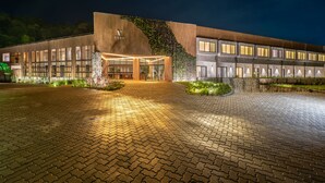 A modern building with a prominent 'VERT' sign, a well-lit entrance, and a paved driveway. - Vert Hotel Spa (Itatiaia)