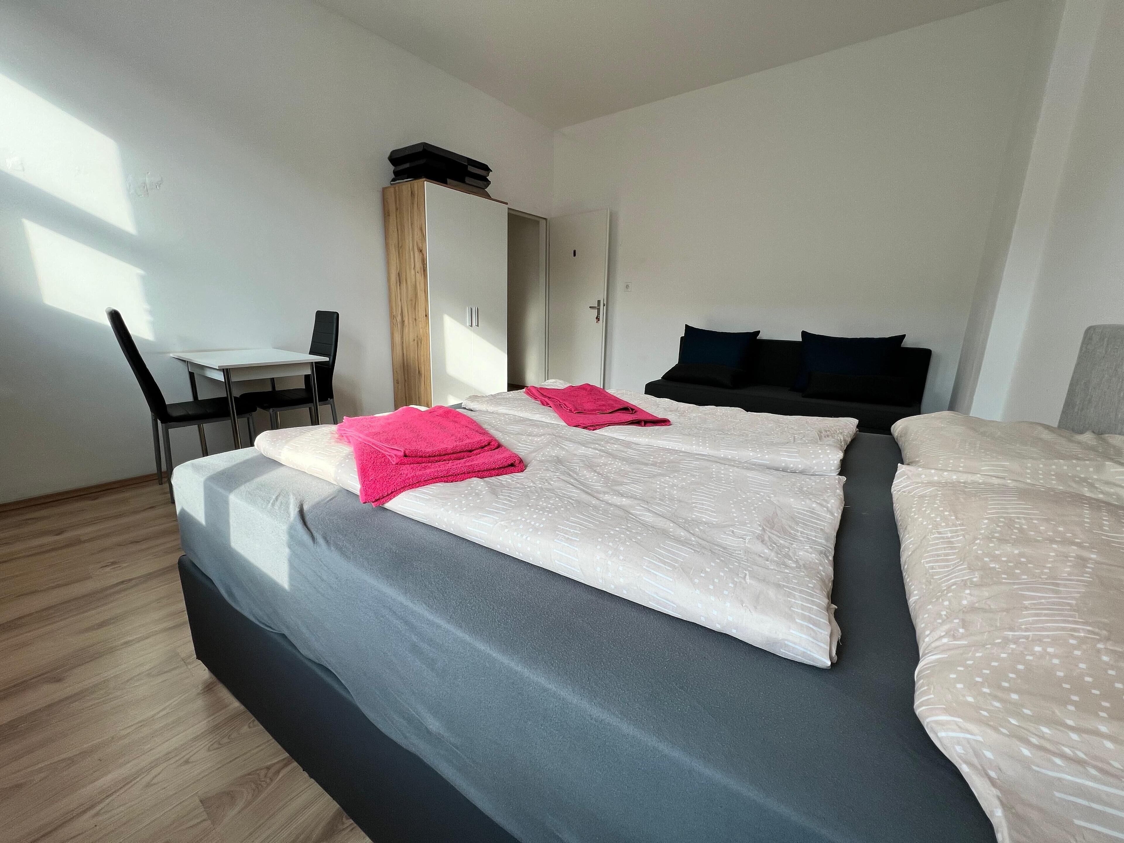 A hotel room with a bed, a desk, and a chair.