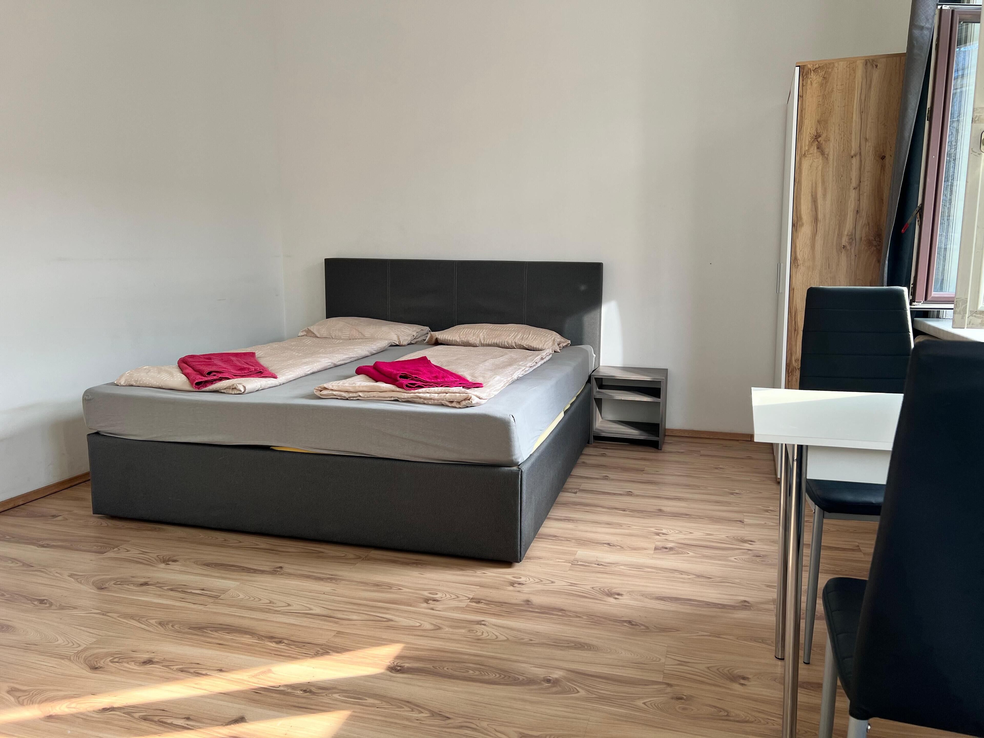 Un dormitorio moderno con cama, mesitas de noche y escritorio.