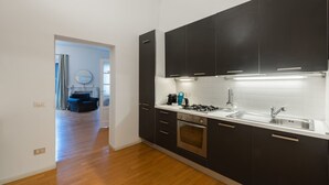 A modern kitchen with dark cabinets, a stainless steel sink, and a gas stove.