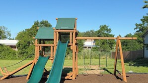 A playground with two slides and a swing set.