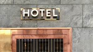 A hotel entrance with a metal gate and a sign above it. - Zzz Dreamscape Hotel - Self Check-In & Digital Key (Stockholm)
