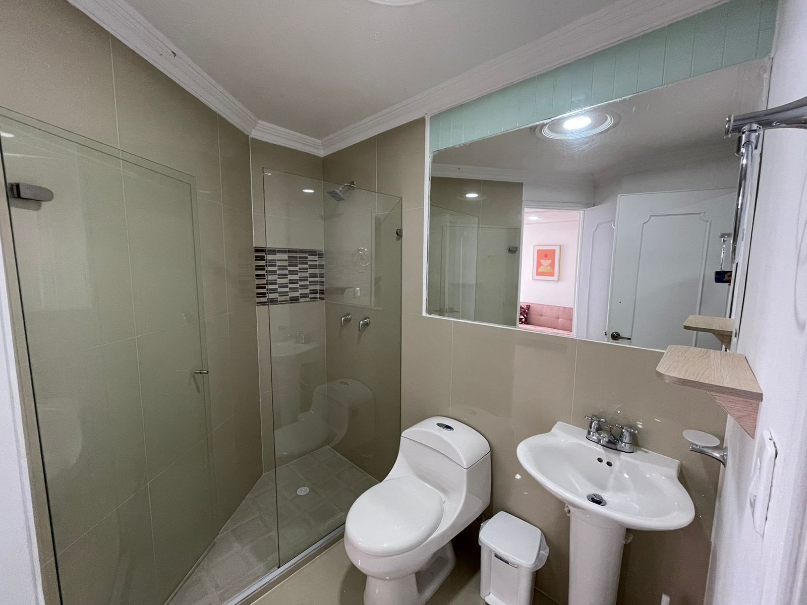 Une salle de bain avec une douche à parois de verre, des toilettes et un lavabo.