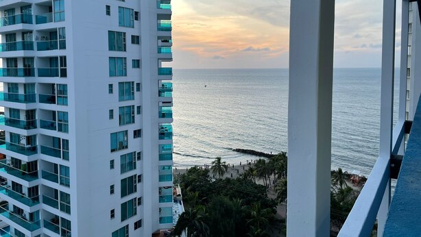 A high-rise building with multiple balconies overlooking a beach. - Apartamentos en Edificio Portofino ICDI (Cartagena)