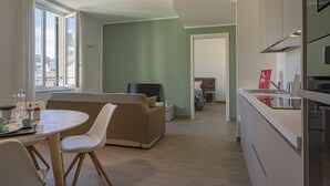 A modern living room with a sofa, a dining table with chairs, and a kitchen area with a counter and cabinets. - Brignole de Ferrari - 401 by Wonderful Italy (Genoa)