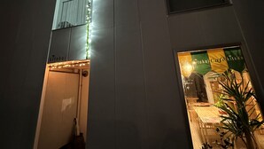 A building with a prominent illuminated sign and a storefront with a sign that reads "Tokoi Café". - Arts Dobashi (Hiroshima)