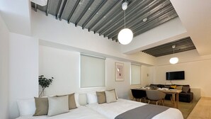 A modern hotel room with a large bed, a desk, and a television. - Arts Dobashi (Hiroshima)