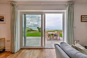 A room with a sliding glass door leading to an outdoor patio with a table and chairs.