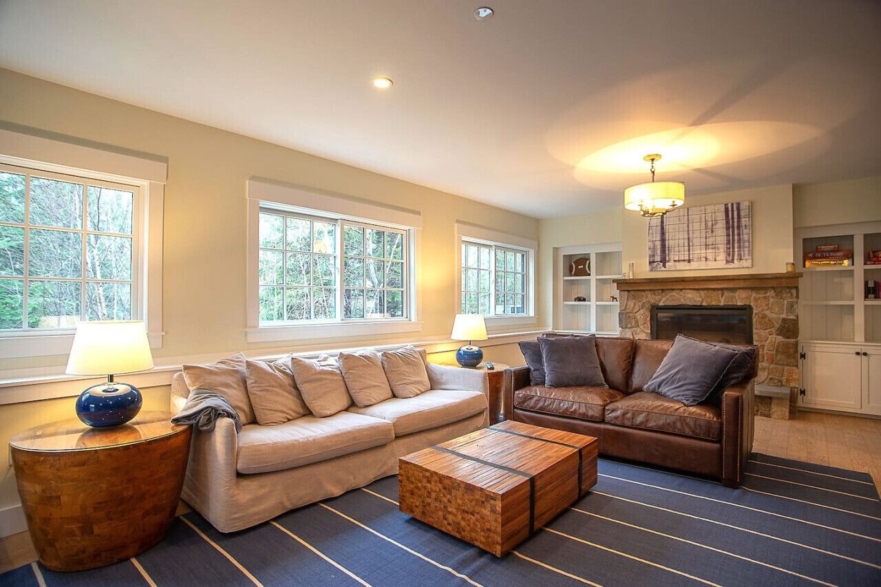 A living room with a sofa, a leather armchair, a coffee table, and a fireplace.