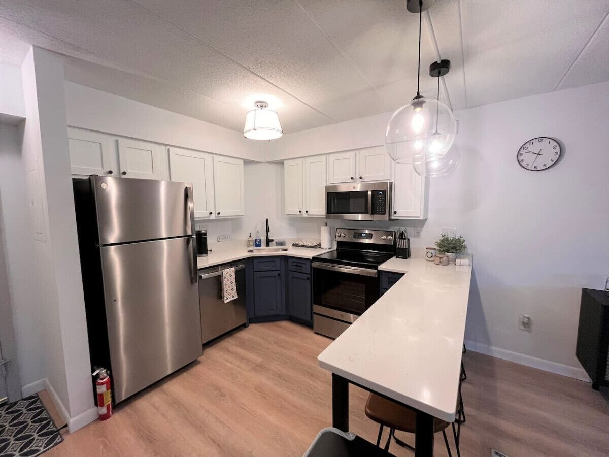 A modern kitchen with stainless steel appliances, white cabinets, and a central island.
