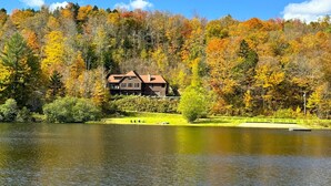 Una proprietà sul lago con una grande casa, un molo e un prato curato.