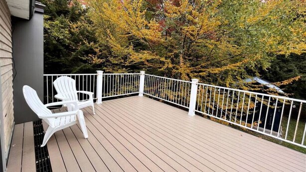 A wooden deck with white railings and two Adirondack chairs. - New! Mt Snow Chalet w/land, privacy, relaxation (Dover)