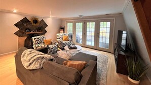A living room with a sofa, armchairs, a coffee table, and a fireplace. - New! Mt Snow Chalet w/land, privacy, relaxation (Dover)