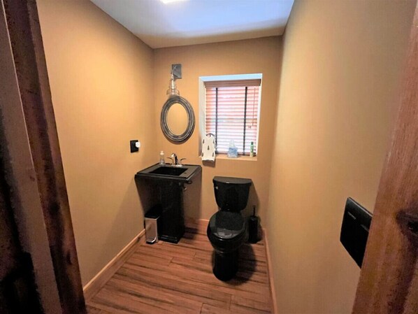 Un baño pequeño con lavamanos, inodoro y ventana.