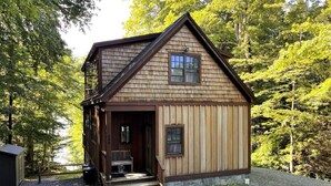 Eine kleine Holzhütte mit Veranda, Fenster und Tür.