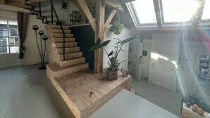 Gradi de fusta amb vista a una habitació inferior.