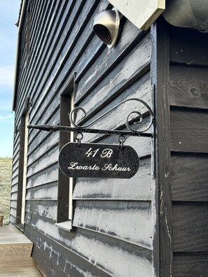 A wooden house with a metal sign reading "41 B Evarte Schuur". - Ruime, Ouderwets Gezellige Voormalige Schuur Midden in de Natuur (Culemborg)