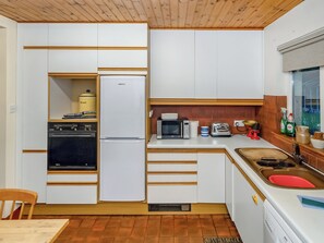Une cuisine compacte équipée d’un four, d’un micro-ondes et d’un grille-pain intégrés.