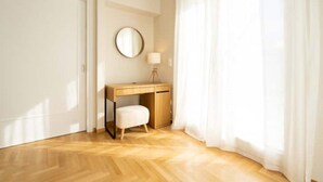 A room with a wooden desk, a round mirror, a white chair, and a lamp. - Corner penthouse in Acropolis (Athina)