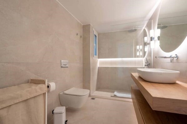 Une salle de bain moderne équipée de toilettes, d’un lavabo et d’une zone douche.