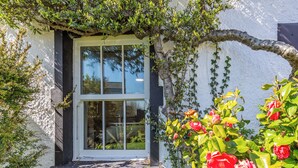 A white building with a window and a small porch. - 3 bedroom accommodation in Silecroft, near Millom (Silecroft, near Millom)