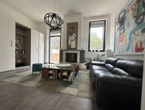 TV connectée, cheminée, table de tennis de table, livres