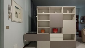 Een kamer met een inbouwkast, een lijst met een afbeelding aan de wand en een plafondlamp.