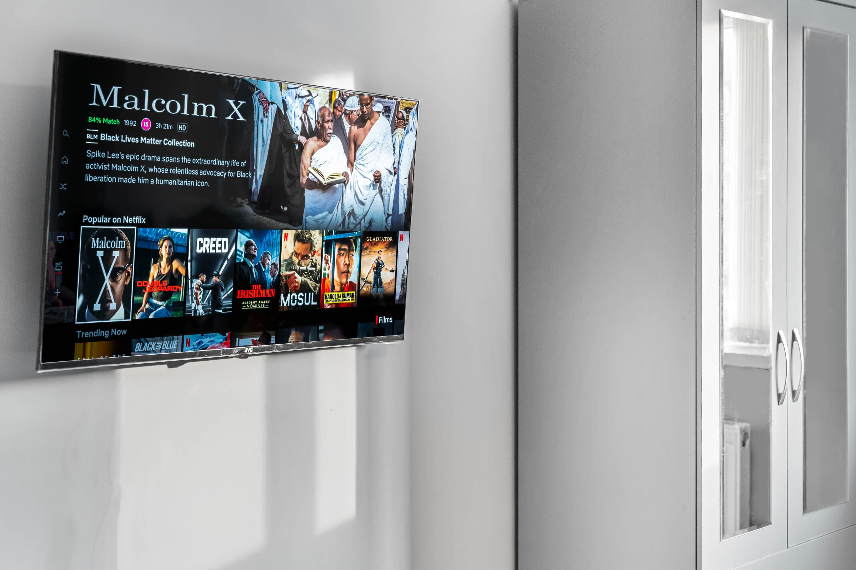 Egy falra szerelt, síkképernyős televízió vetít egy „Malcolm X” című filmet, amelyhez felirat és rövid leírás is tartozik. A film alatt kisebb képek formájában jelennek meg más filmek és televíziós műsorok.