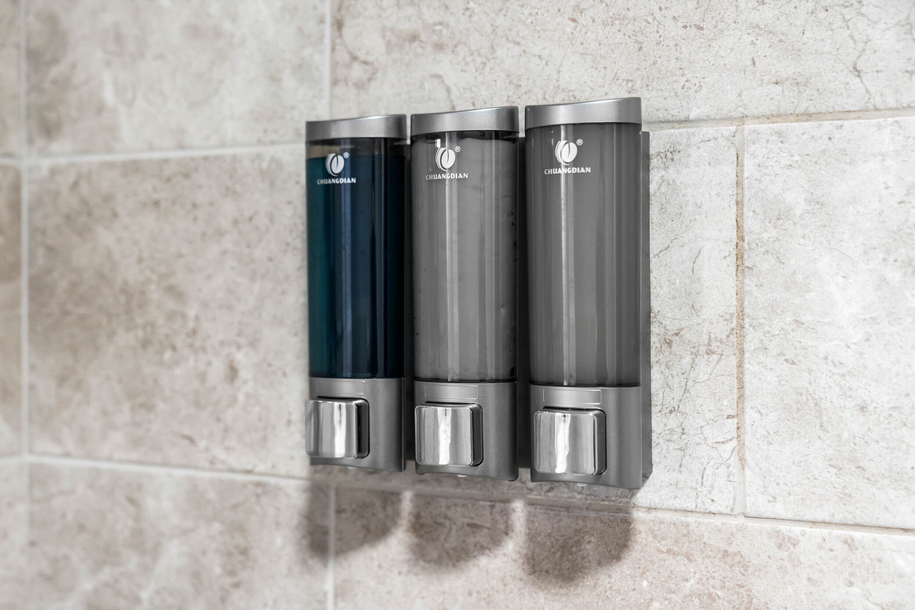 Three metallic dispensers labeled 'CHILANGDIAN' mounted on a tiled wall.
