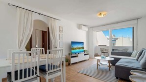 Un salon moderne comprenant un coin repas, un canapé, un téléviseur et un balcon avec vue.