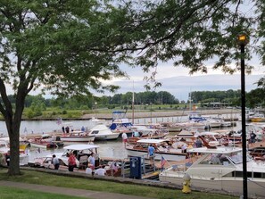 A marina with boats docked, a grassy area in the foreground, and a body of water in the background. - Walk to everything! NEW Beautiful Home in Huron! (Huron)