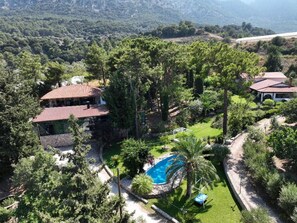 A large house with a swimming pool surrounded by lush greenery and trees. - Agrology Lux (Rhodes)