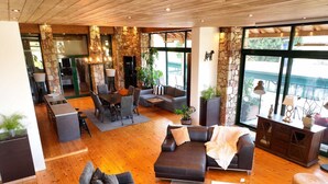 A spacious living area with a fireplace, seating, and large windows. - Agrology Lux (Rhodes)