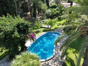 A swimming pool surrounded by lush greenery and a stone deck. - Agrology Lux (Rhodes)