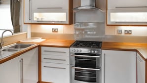 A modern kitchen with stainless steel appliances, wooden countertops, and white cabinetry. - 2 bedroom accommodation in Lamplugh (Lamplugh)