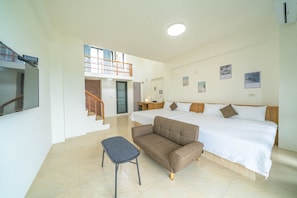 A hotel room with a bed, a sofa, a small table, and a staircase leading to an upper level. - YUTAI VILLA (Wujie)