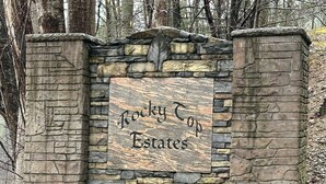 En stenvæg med et skilt, der står "Rocky Top Estates".