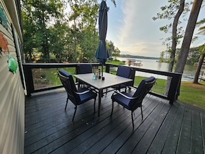 Puisesta laudasta rakennettu terassi, jossa on pöytä ja tuolit, ja josta avautuu näkymä järvelle.