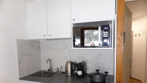 A compact kitchen with a sink, a kettle, a coffee maker, and a microwave. - 200m from ski slopes, 3rd floor, balcony, parking, tv, ski locker, 23m², Les Contamines-Montjoie (Les Contamines-Montjoie)