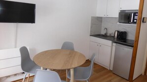 A compact kitchen with a microwave, kettle, and dishwasher. There is a small dining area with a round table and four chairs. - 200m from ski slopes, 3rd floor, balcony, parking, tv, ski locker, 23m², Les Contamines-Montjoie (Les Contamines-Montjoie)