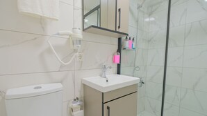 A modern bathroom with a toilet, sink, and shower. - Lucky Hotel İstanbul (Istanbul)