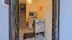 A hotel reception area with a marble floor, a chandelier, a fire extinguisher, and a sign indicating the hotel is in Istanbul. - Lucky Hotel İstanbul (Istanbul)