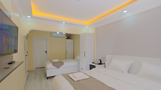 A hotel room with a large bed, a smaller bed, a desk, and a TV. - Lucky Hotel İstanbul (Istanbul)