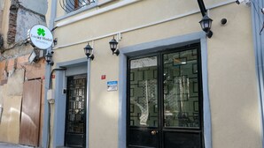 A building with a sign for Lucky Hotel Istanbul, featuring large windows and a door with a security gate. - Lucky Hotel İstanbul (Istanbul)