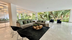 A modern living room with a sectional sofa, a coffee table, and two chairs. - Park Life Bolongo (Bucerías)