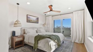 A bedroom with a bed, bedside table, lamp, ceiling fan, and a view through the window. - Private Caldwell Guesthouse w/ King Bed, Balcony & Kitchenette (Caldwell)